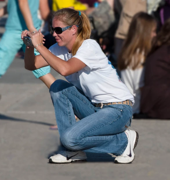 a girl crouching in front of a crowd of people