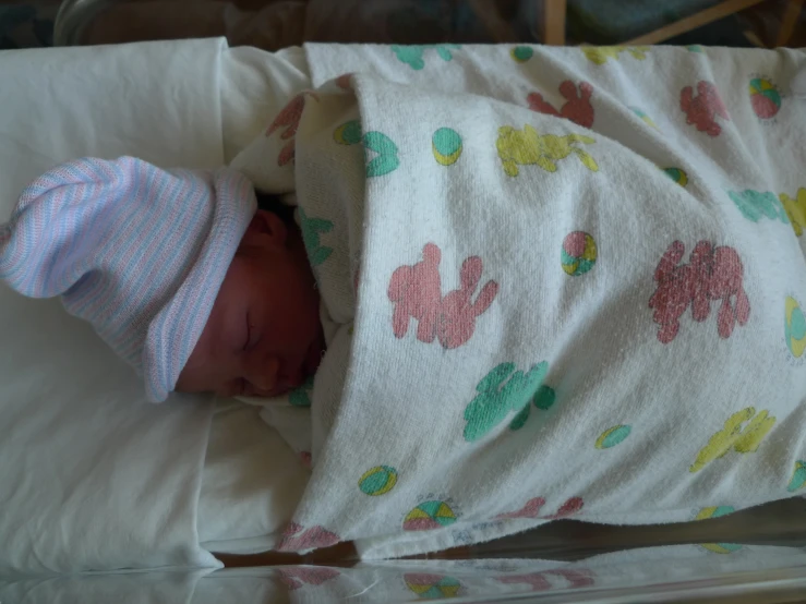 a newborn wrapped up in a blanket and hat