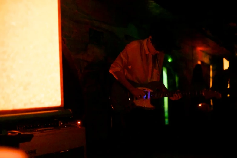 people in a dark room with a lit up area