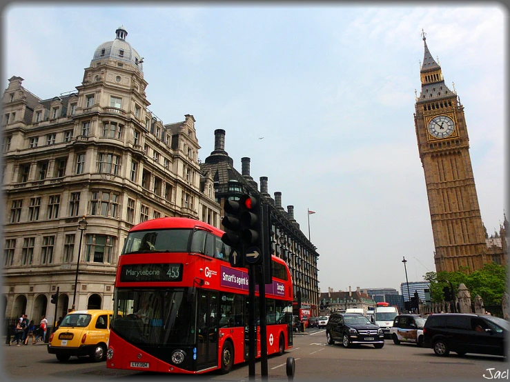 a red double decker bus on a street next to tall buildings