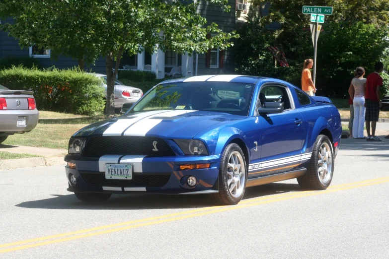 a blue sports car parked on the side of a road