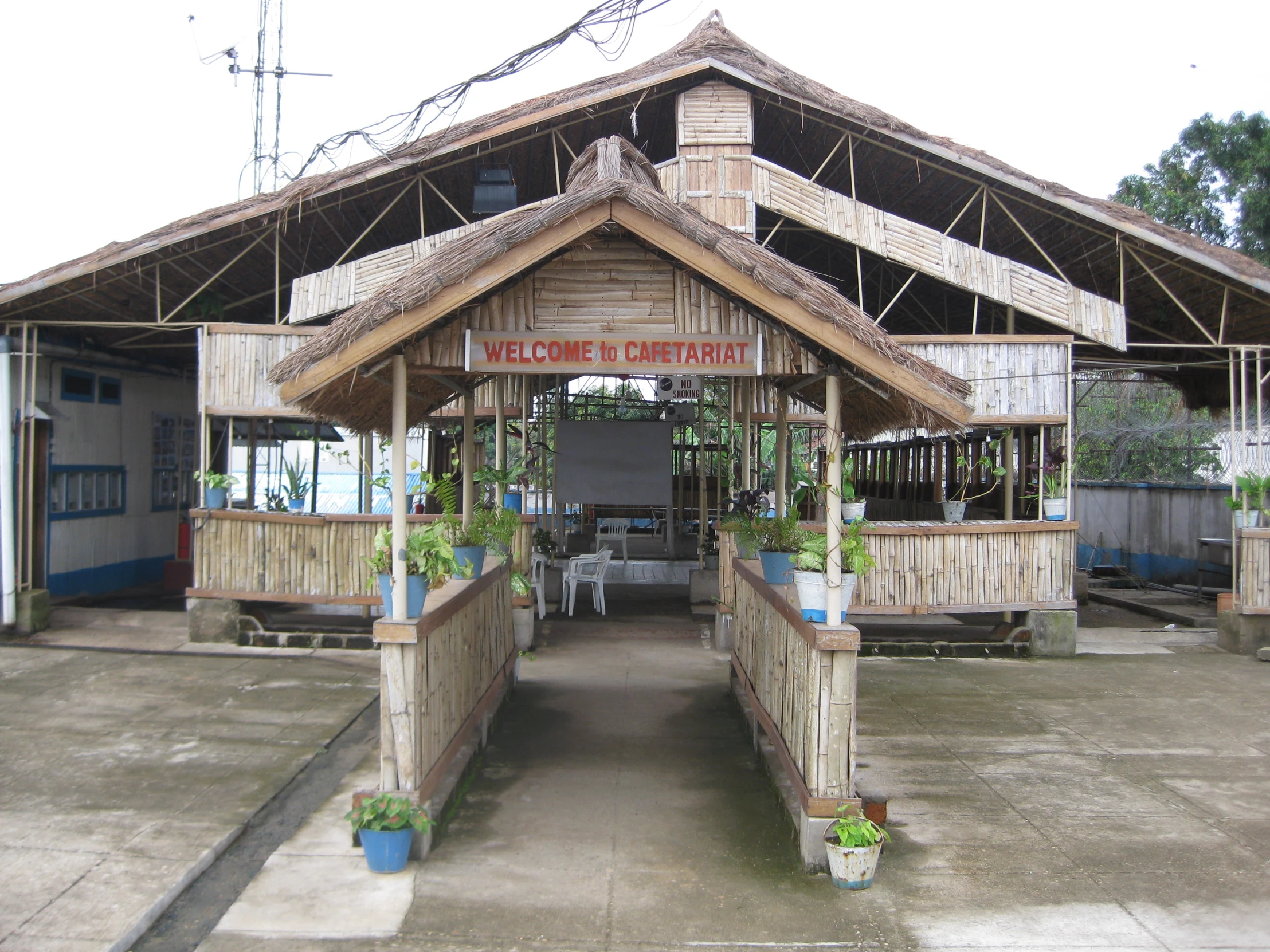 the building has a wooden fence and plants on both sides