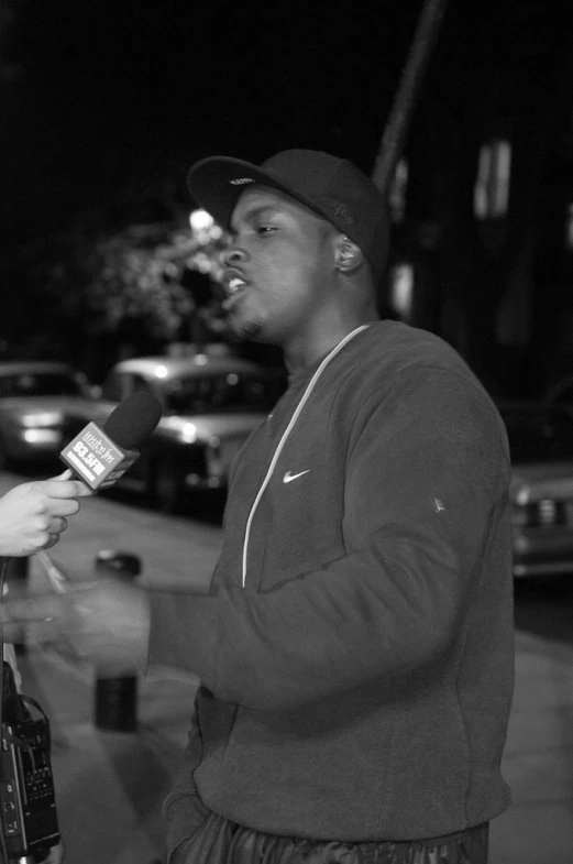 a man on the street holding a microphone