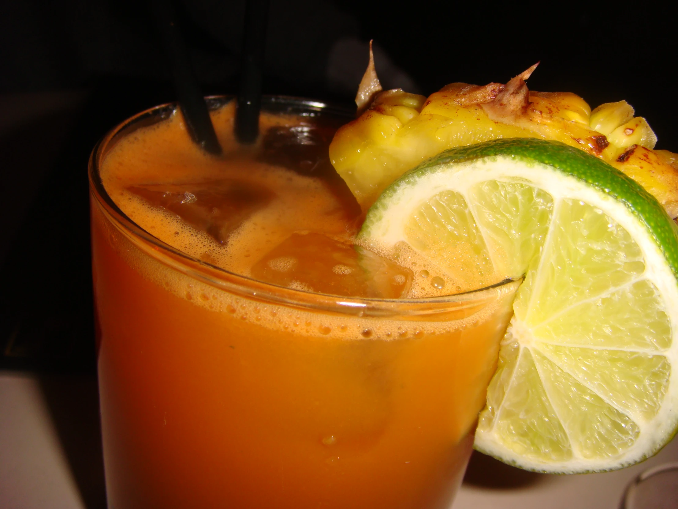 a glass with some fruit next to a lime