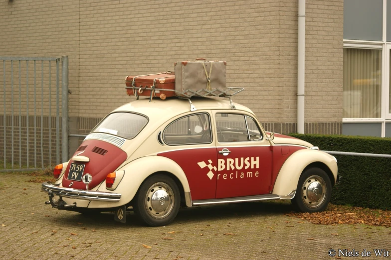 the old car is traveling down the street carrying luggage