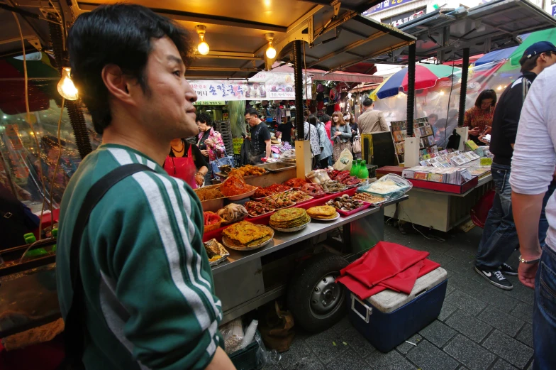 there is a man at the market with a large tray of food