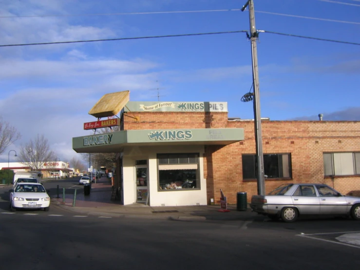 a city diner sits next to a car and bus