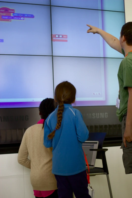 children playing video games on a large screen at school