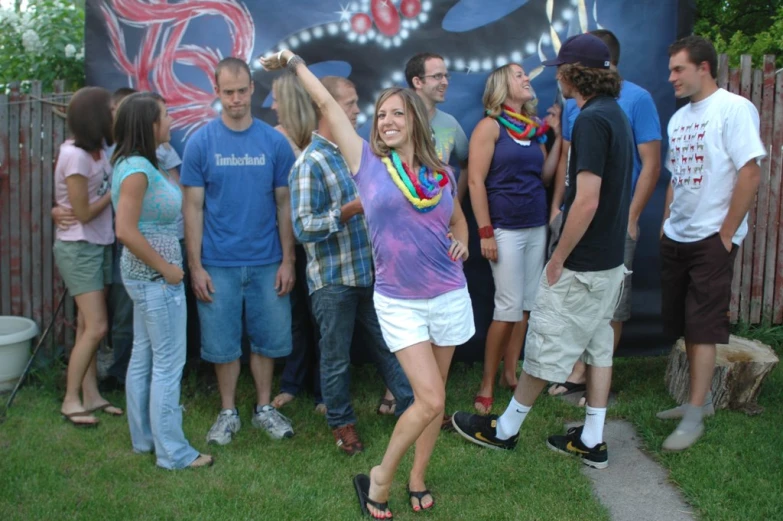 a young lady is dancing outside surrounded by friends