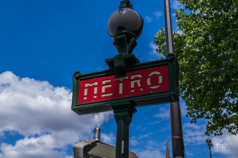 a red metro sign with an orange word above it