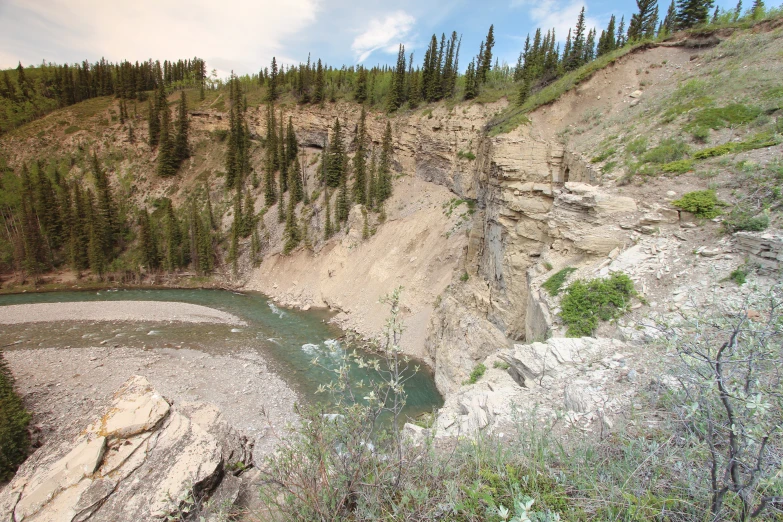 an old quarry sits beside a pond, with trees in the background