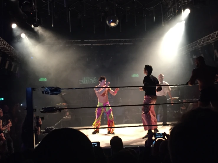 two men are boxing on the ring in front of the crowd