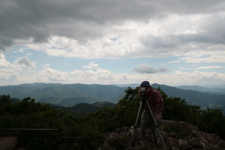 a man taking pictures of the sky in the mountains