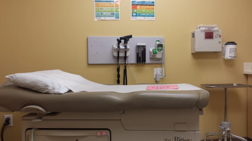 the hospital room has two machines and a bed