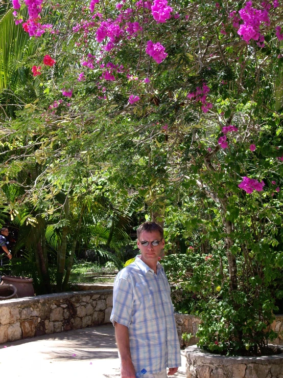 a man walking down a path next to a bunch of flowers