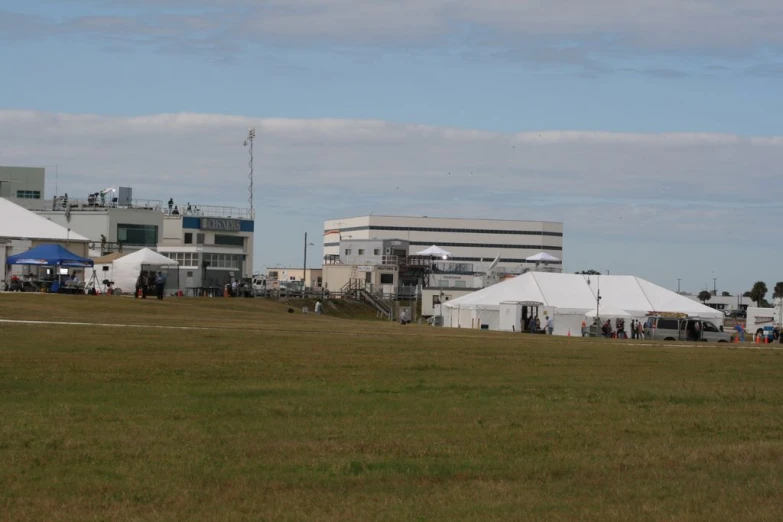 large tents outside in a grassy field in front of buildings