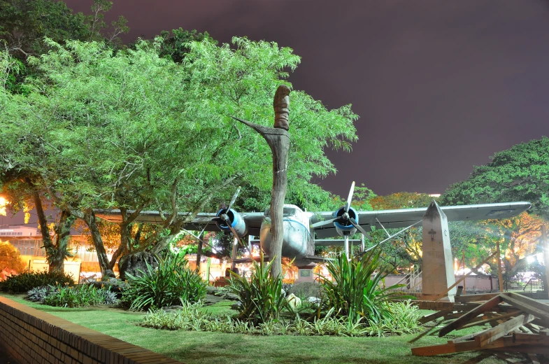 a statue of an airplane in front of a building at night