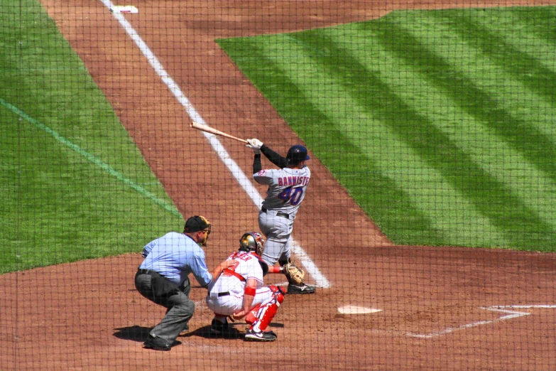 an umpire stands behind a player at home plate