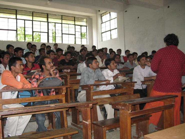 a group of people sitting in school desks