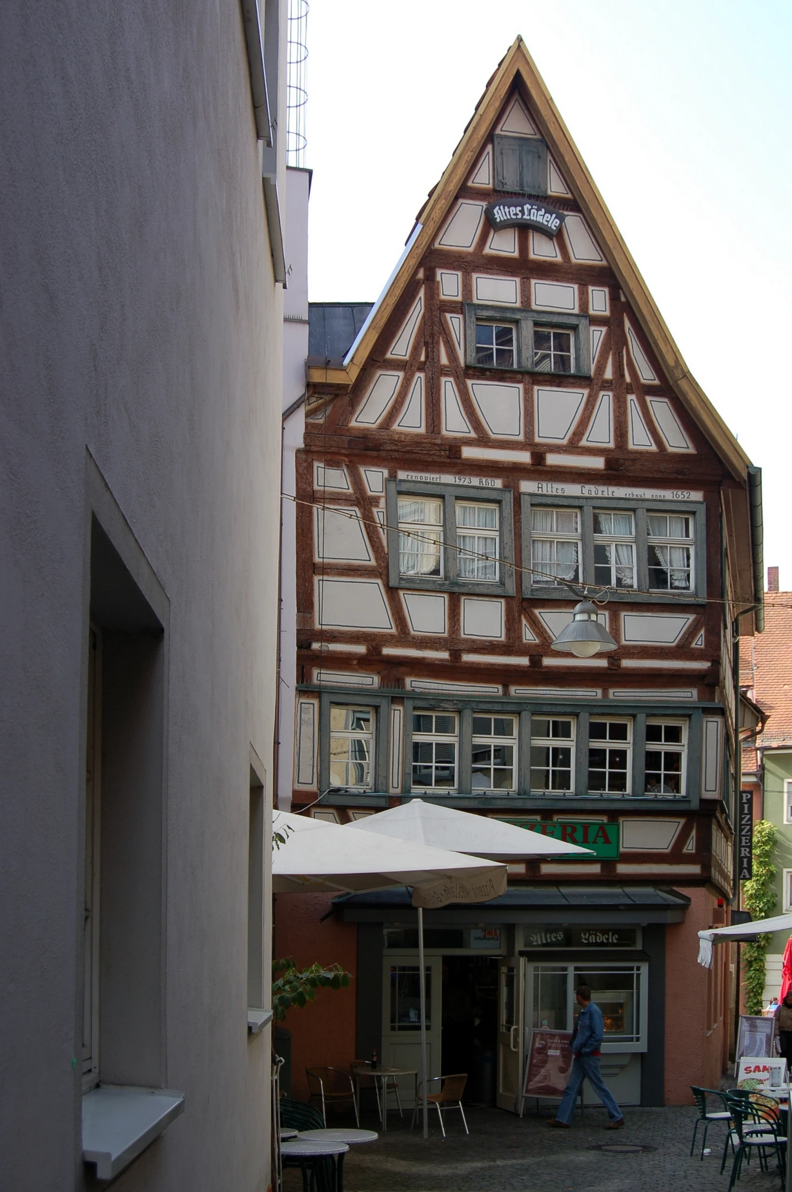 people are walking down an alley next to buildings