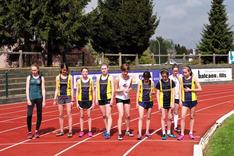 a team of young people standing on a race track