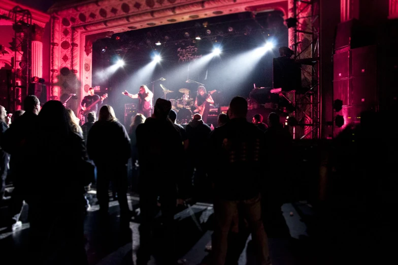 several people watching a concert with some lights shining