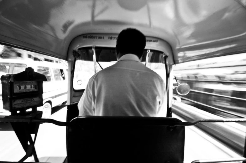 man driving a transit bus on a street