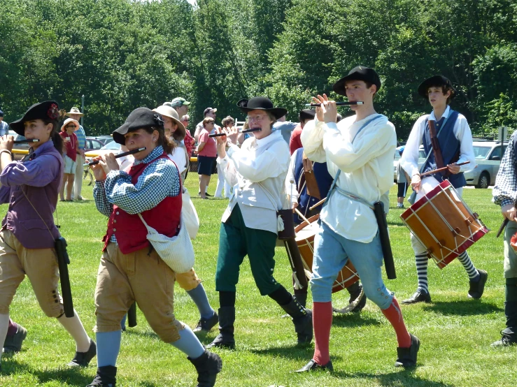 boys dressed in colonial era costumes playing with musical instruments