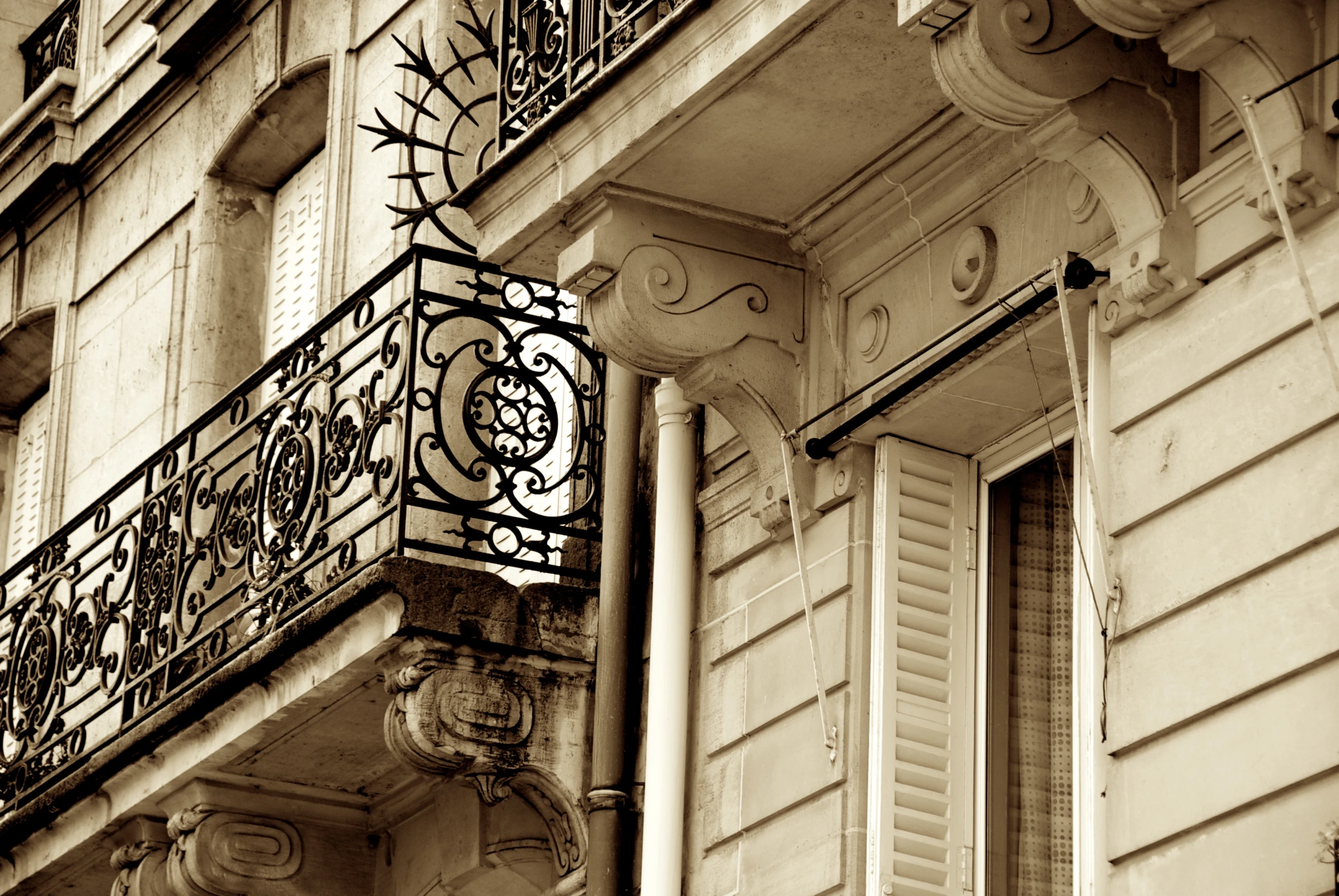 the iron balcony and shutters on a tall building