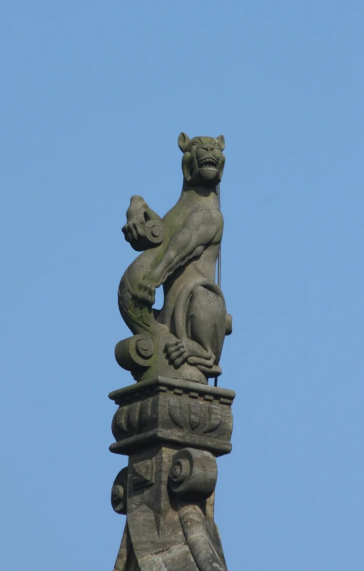 a statue of two cats sitting on a stone pedestal