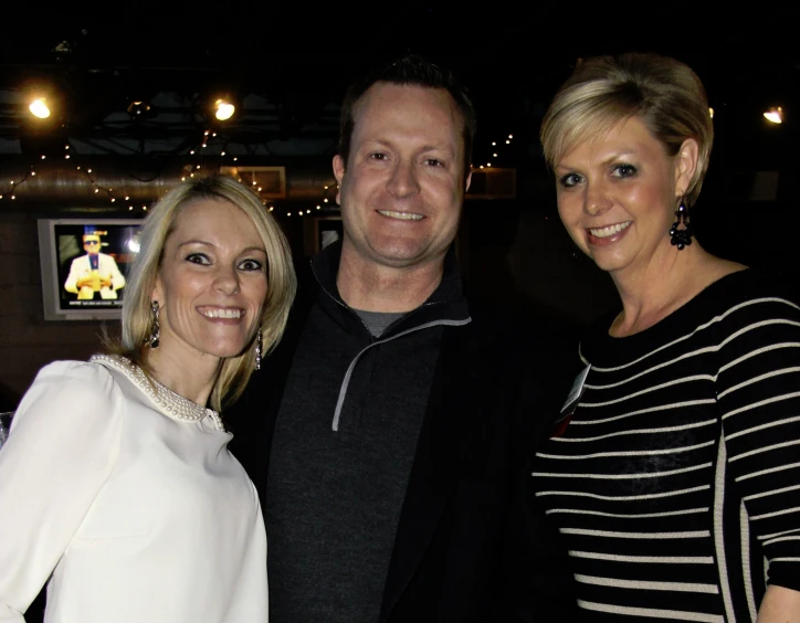 a man, woman and baby posing for a picture at a party