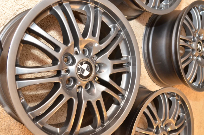 some rims on different types of wheels sit on the floor