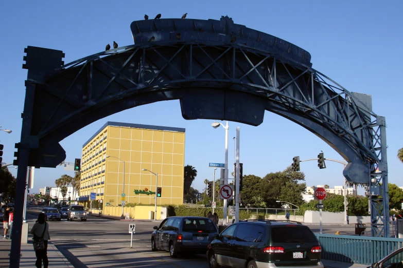 a busy street with cars and people walking on a bridge