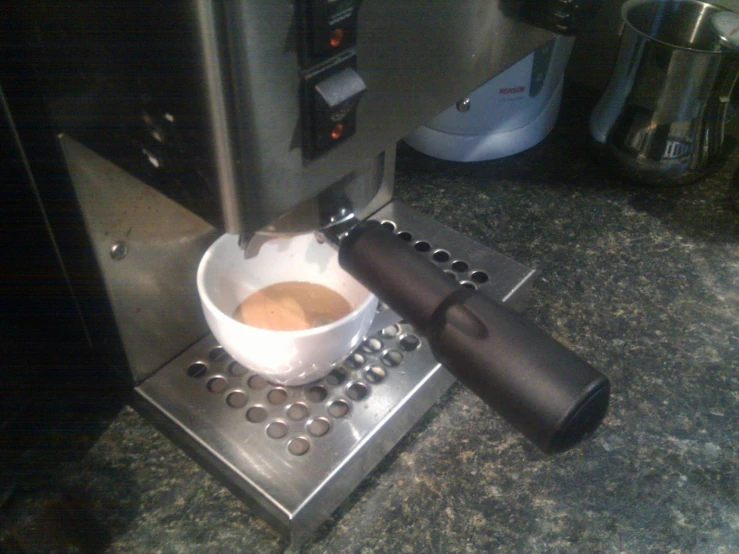 an espresso machine making milk for a cup