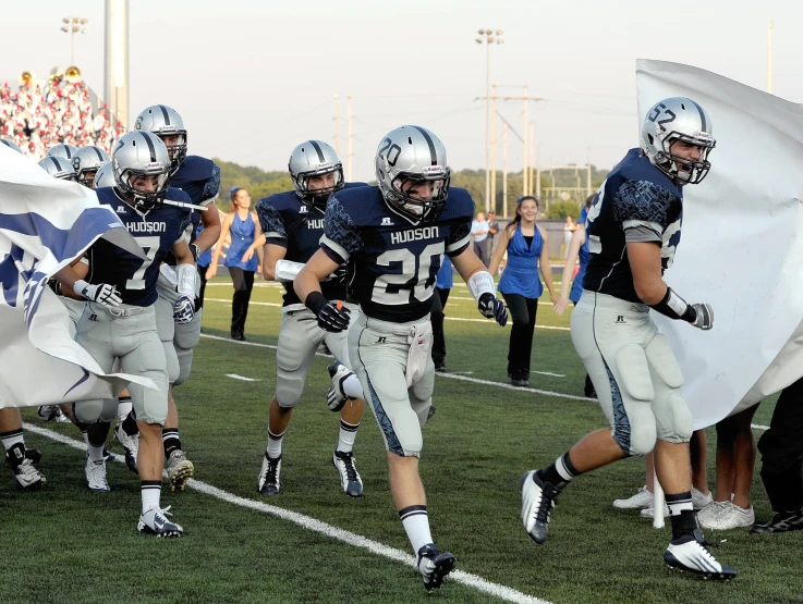 a group of football players running onto a field