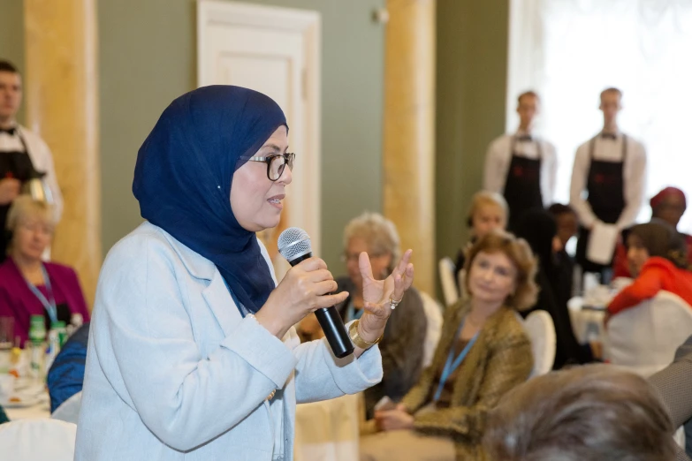 a woman speaking at a business luncheon