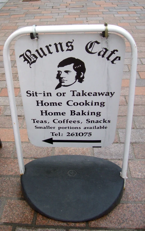 a sign advertises an outdoor cafe that is located on the sidewalk