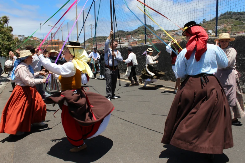 several people dressed in period clothes, dressed in colorful clothing, on a road
