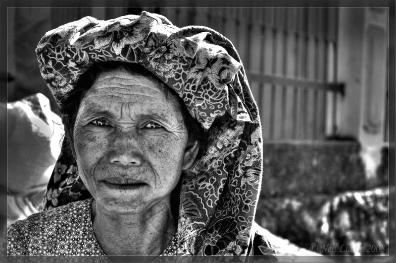 an old woman wearing a blanket and posing for the camera