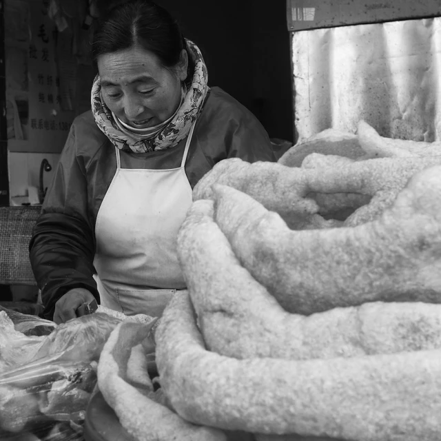 a woman in an apron stands near some towels