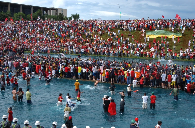 many people are gathered around in the water as a crowd watches