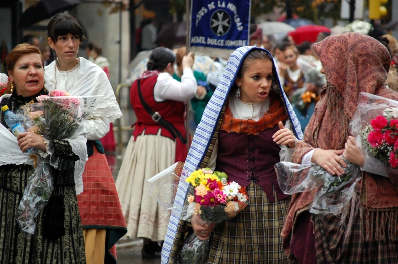 a woman in costume carries her bouquet as others wait nearby