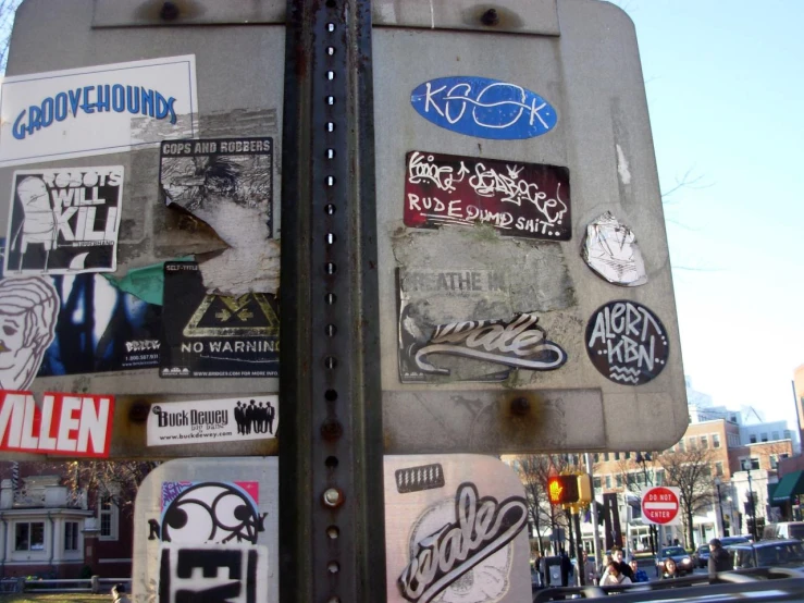 a number of stickers are attached to a steel pole