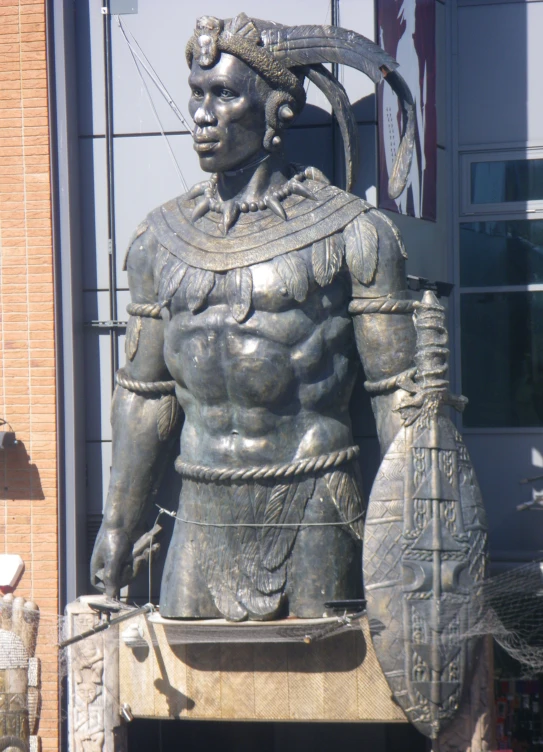 a statue in front of a brick building