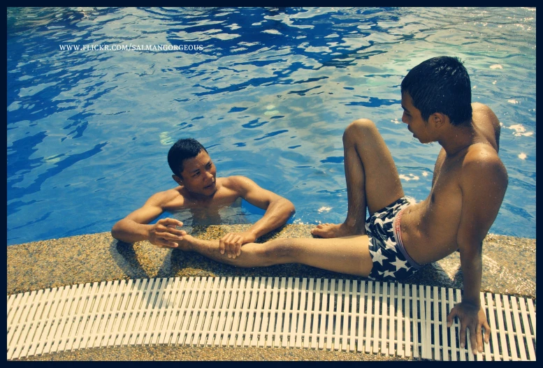a man and a boy at a pool playing around