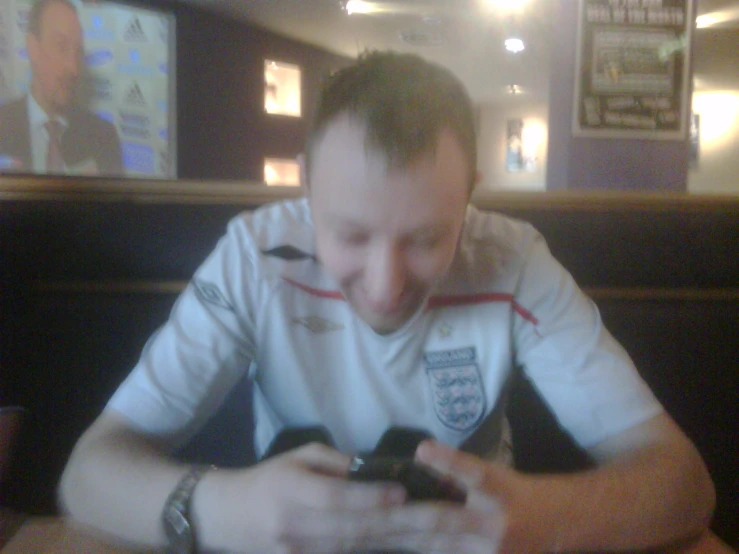 a man sitting at a table looking at his cell phone