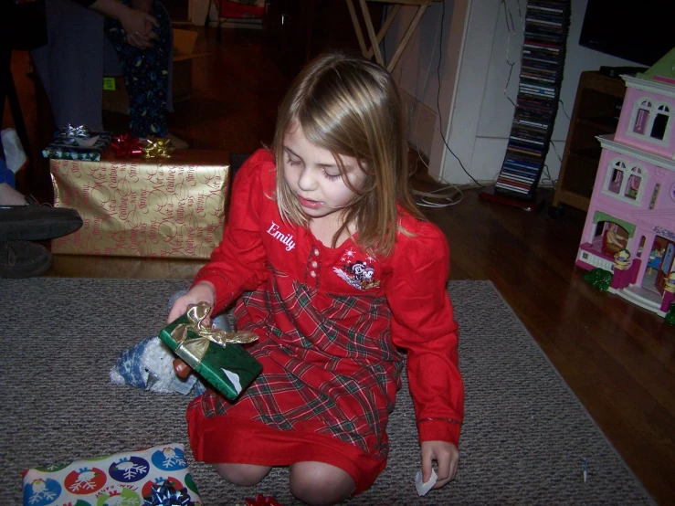 the  sits on the floor with two small gift boxes