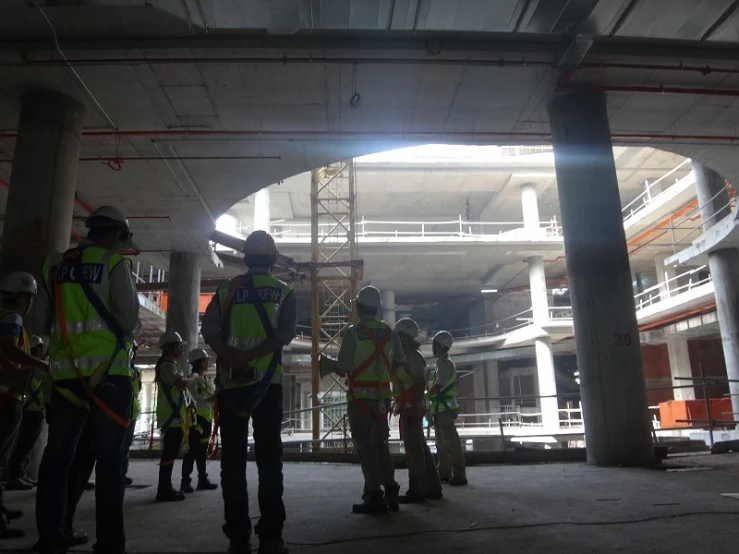 a group of construction workers standing under a bridge