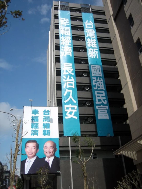 two banners depicting the two presidential figures are seen on the side of a tall building
