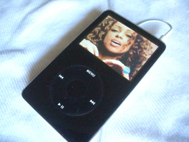 an mp3 player is on the bed with a headphone